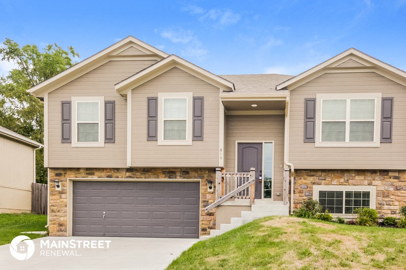 a beige house with a brown garage door
