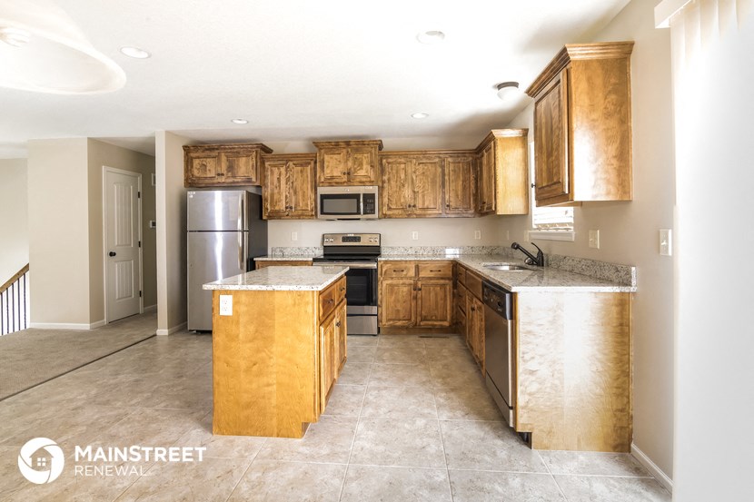 a kitchen with wooden cabinets and stainless steel appliances