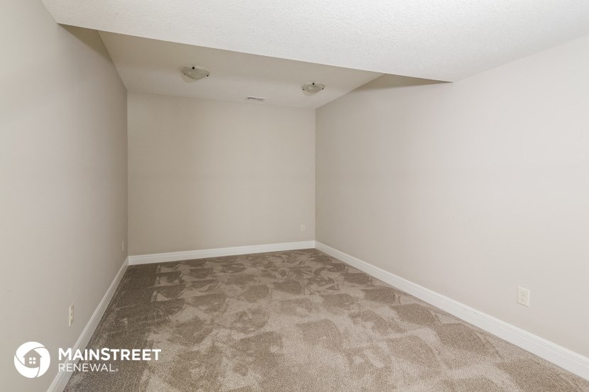 the upstairs bedroom of an apartment with carpet and white walls