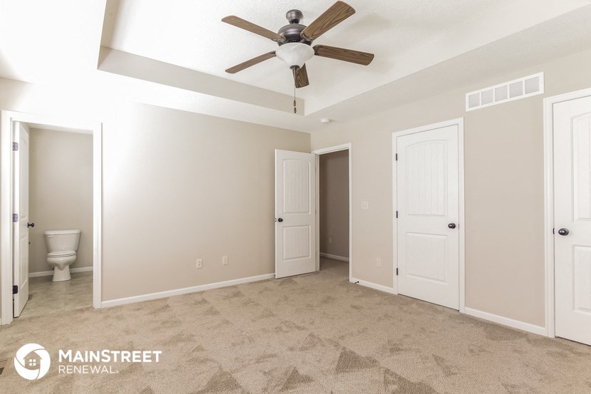 the master bedroom has a ceiling fan and a closet