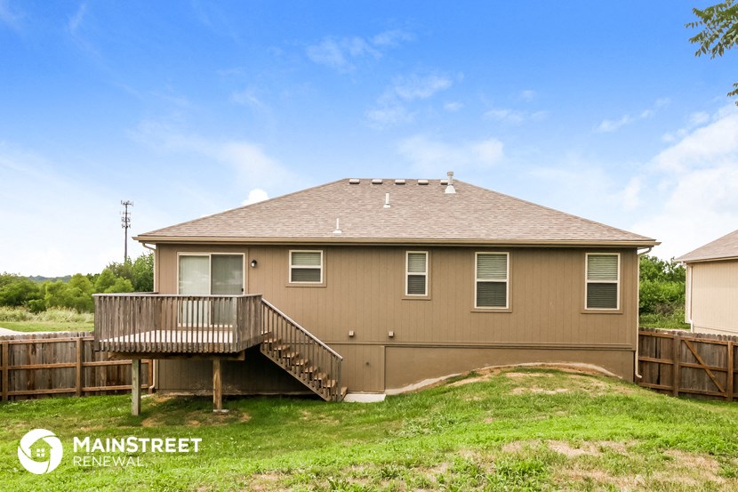 the view of the back of a house with a deck