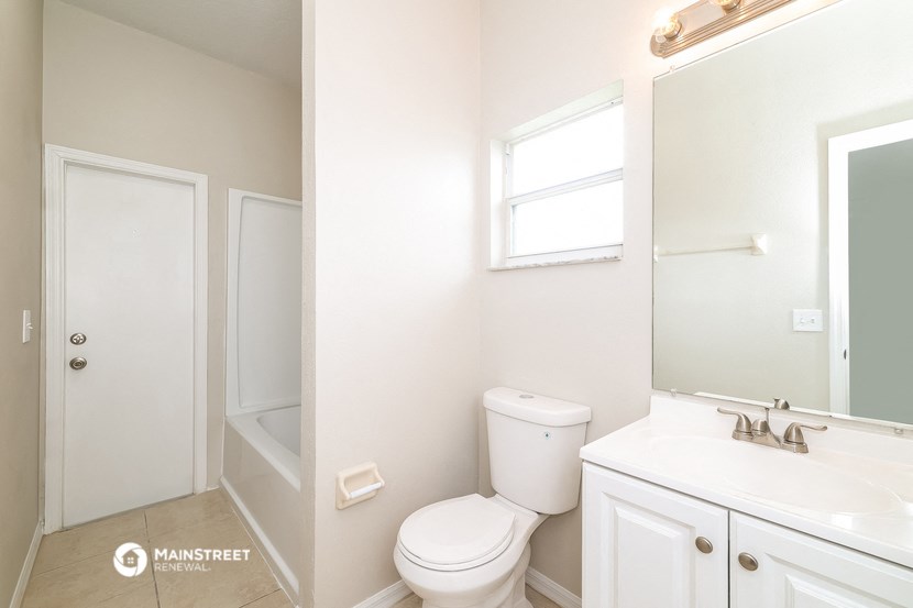 a bathroom with a toilet and a sink and a mirror