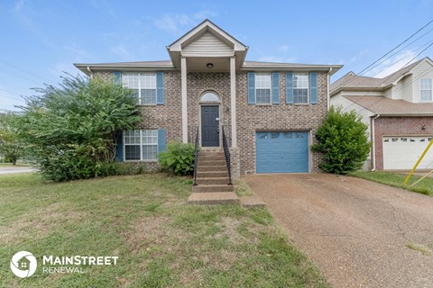the front of a brick house with a blue garage door