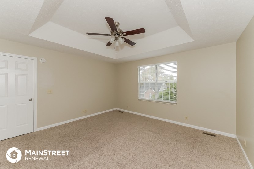the living room of an empty house with a ceiling fan