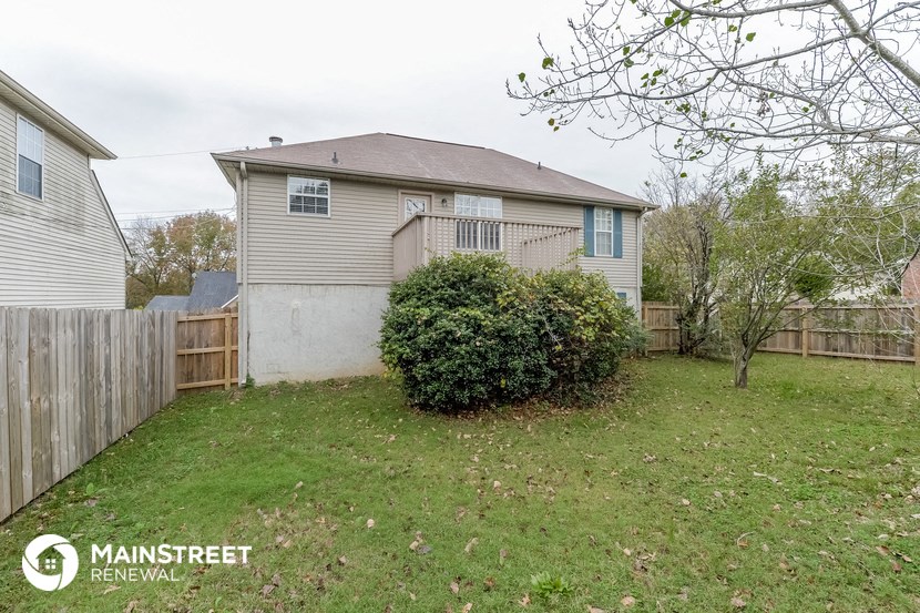 the backyard of a house with a yard and a fence