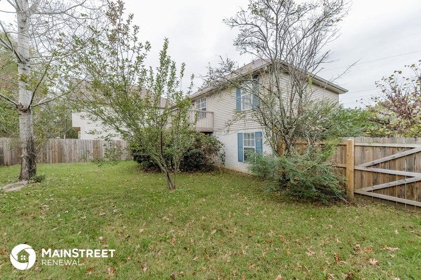 a house with a yard and a fence in front of it