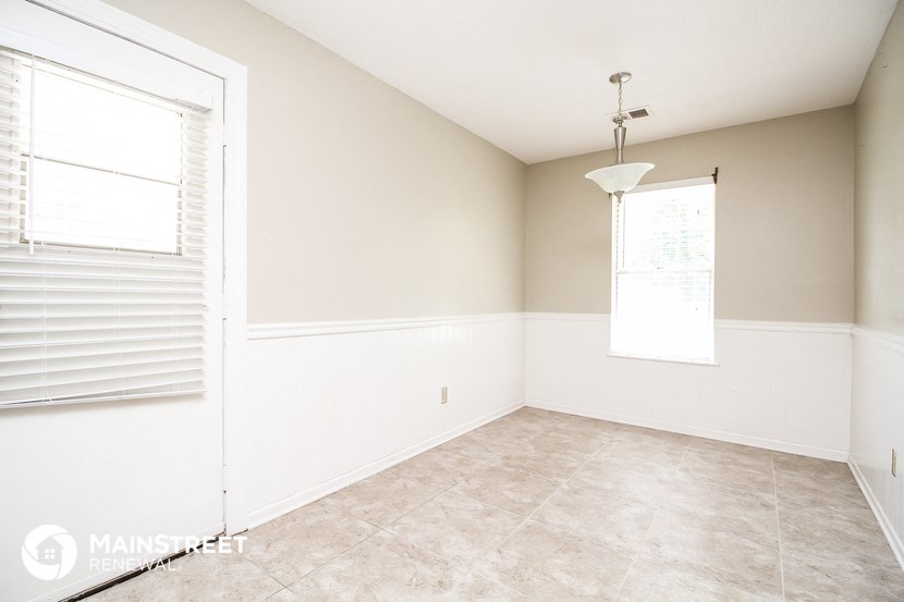 an empty room with a large window and white walls