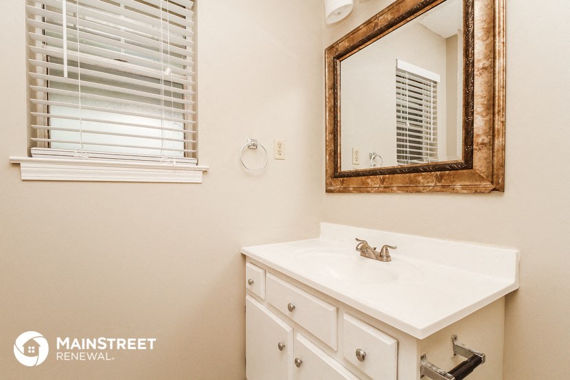 a bathroom with a white sink and a mirror