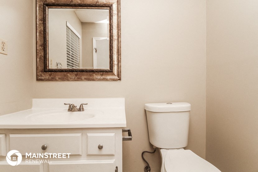 a bathroom with a toilet and a sink and a mirror