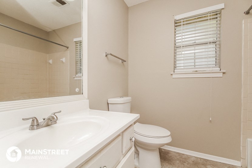 a bathroom with a sink toilet and a mirror