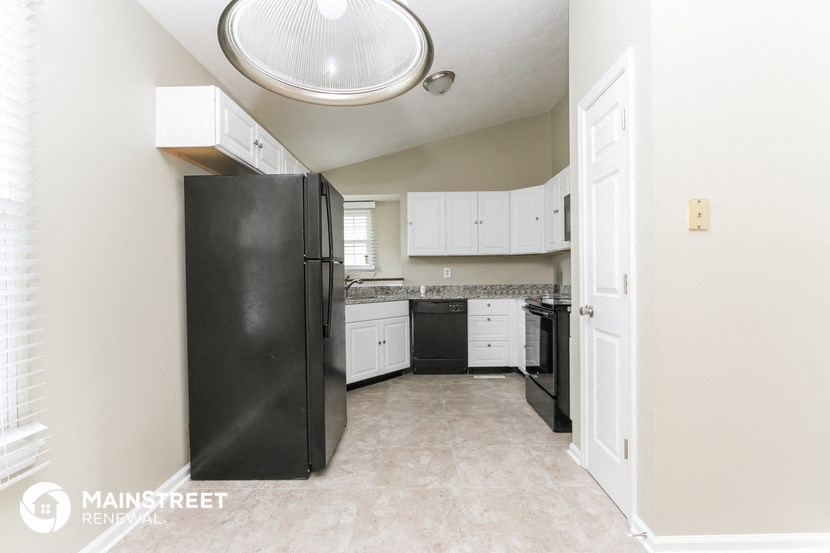 a kitchen with white cabinets and black appliances and a black refrigerator