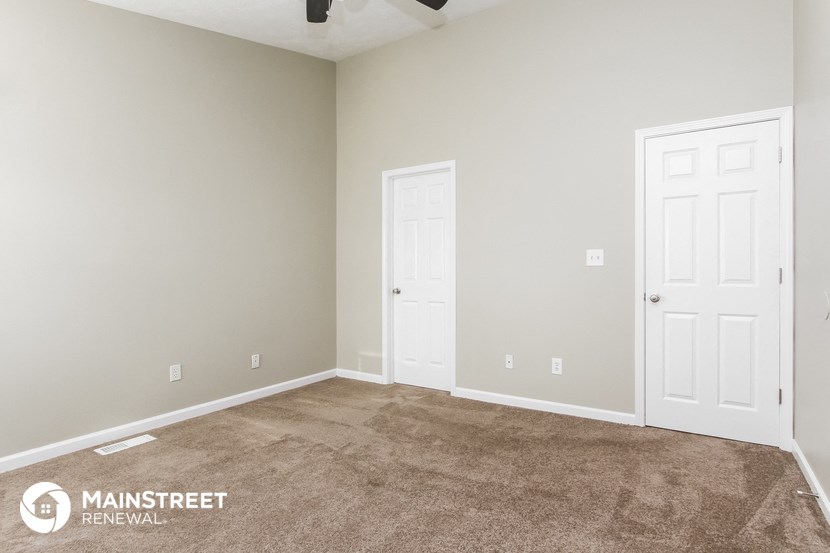 a room with a carpeted floor and two doors