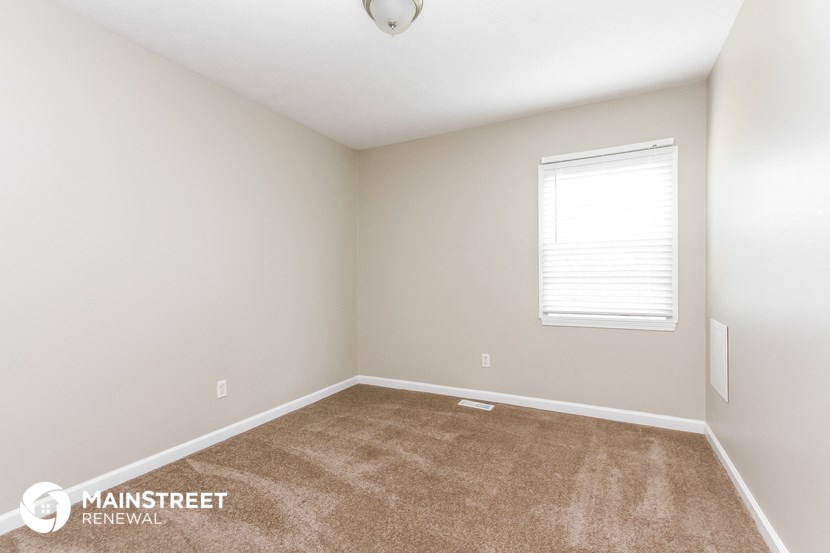 the upstairs bedroom with carpet and a window