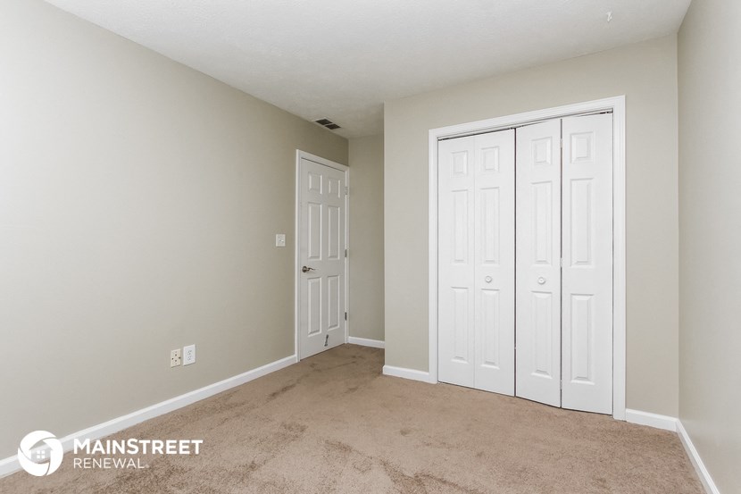 a bedroom with two closets and a carpeted floor