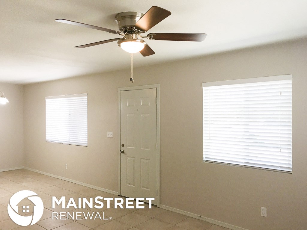 an empty room with a ceiling fan and a door