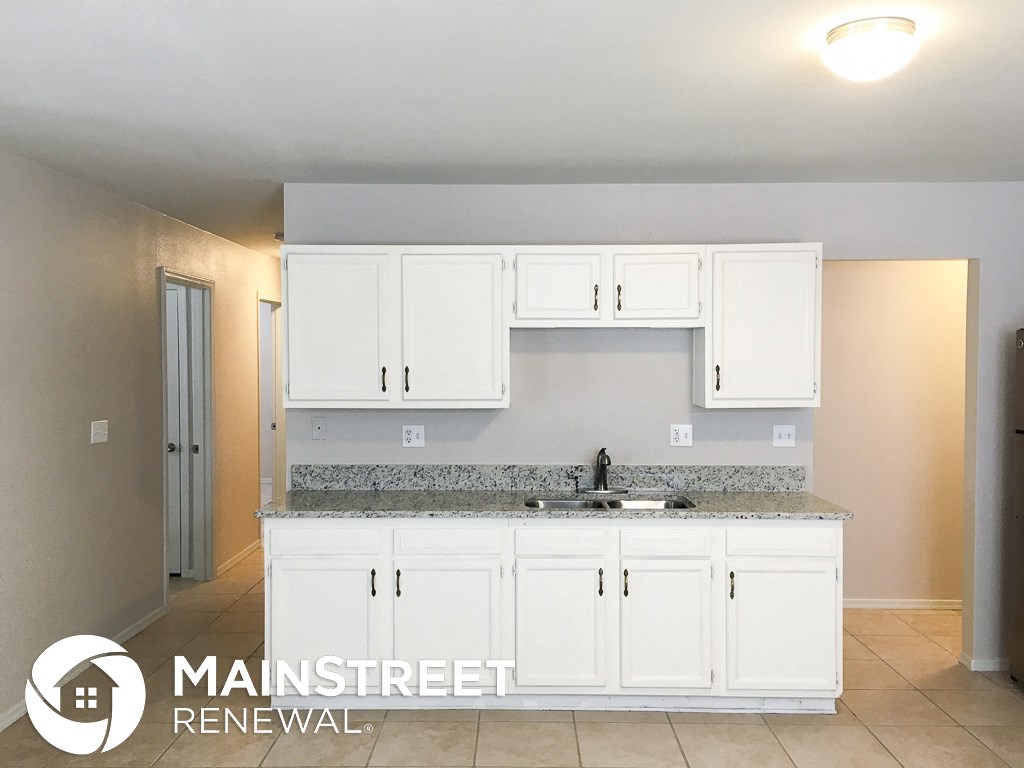 a kitchen with white cabinets and a counter top and a sink