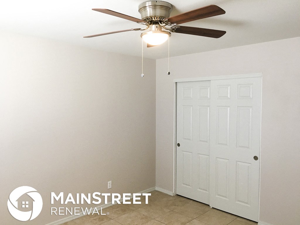 a bedroom with a ceiling fan and a closet
