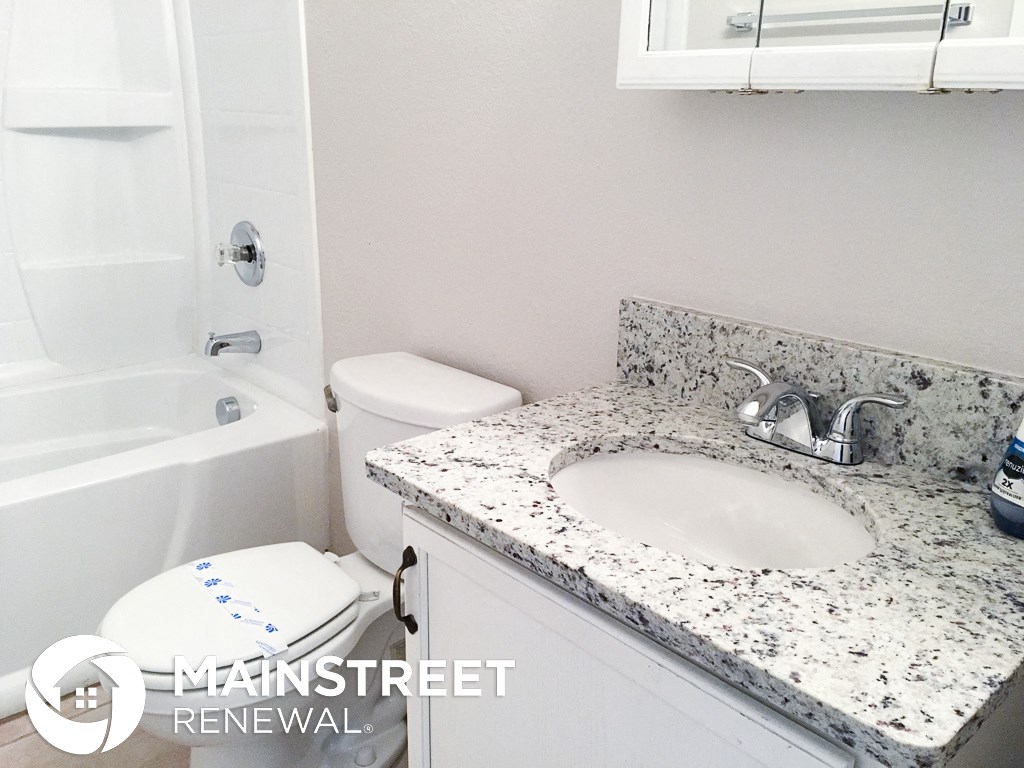a bathroom with a sink and a toilet and a bath tub