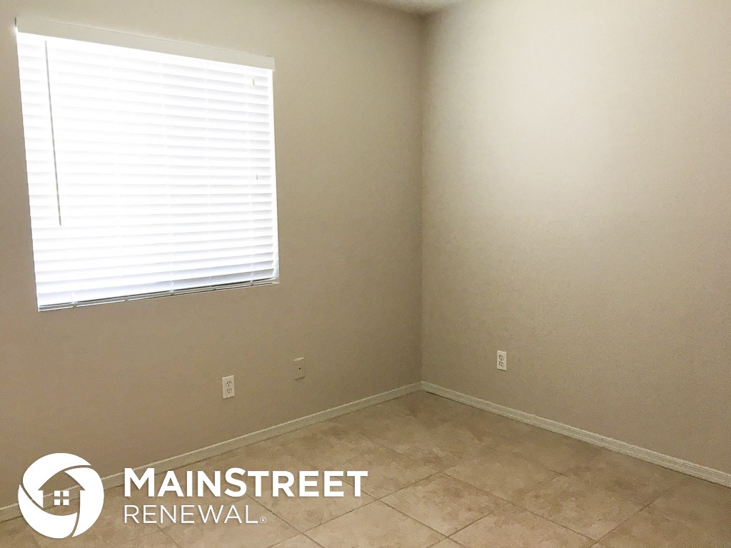 a small room with a window and a tiled floor