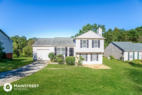 a white house with a lawn and a driveway