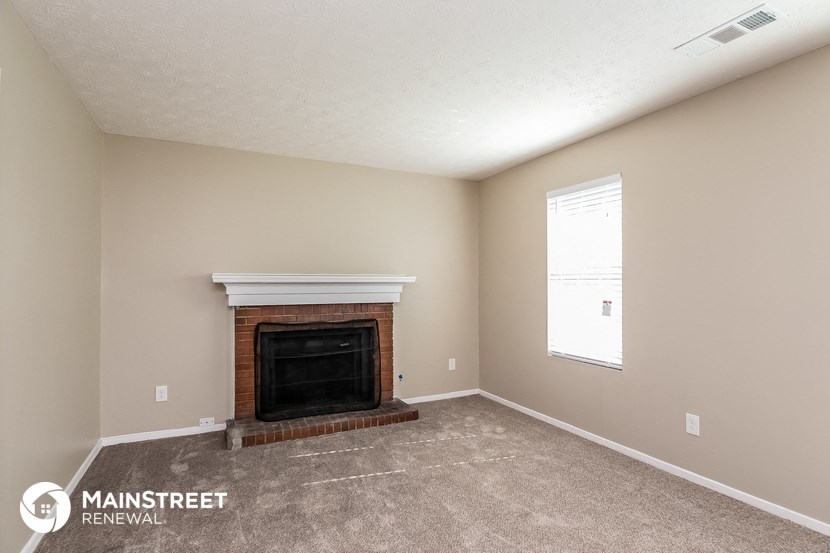 the spacious living room with fireplace and carpeted flooring
