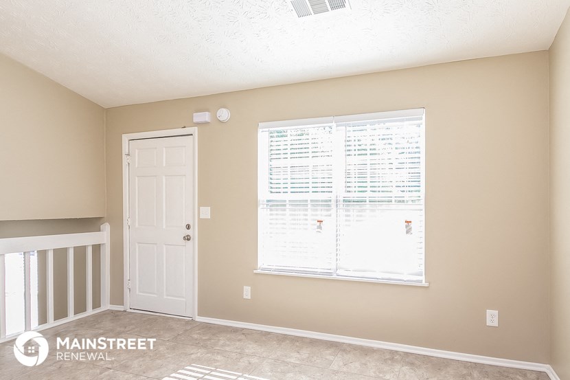 a living room with a large window and a white door