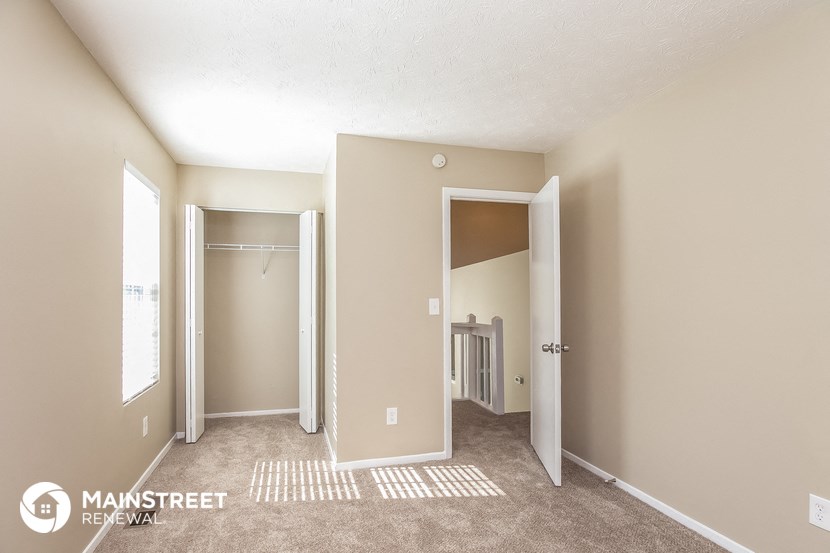 a bedroom with a closet and a door to a bathroom