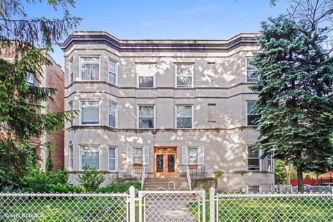 a large house with a fence in front of it