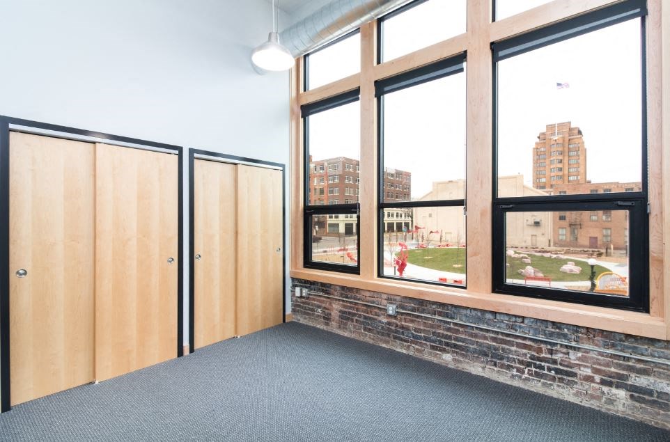 a room with large windows and a brick wall