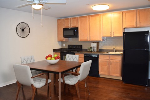 A kitchen with a table and chairs and a clock on the wall.