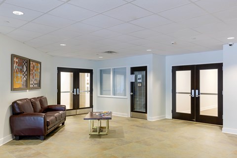 A living room with a brown leather couch and a coffee table.