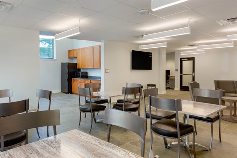 A modern dining room with a long table and chairs.