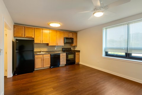 A kitchen with wooden cabinets and black appliances.