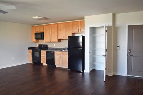 A kitchen with black appliances and wooden cabinets.