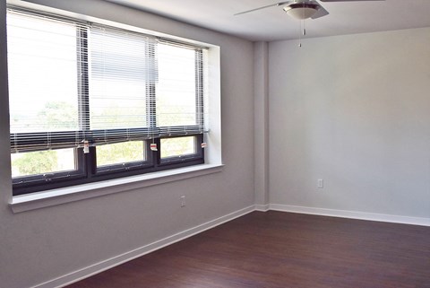 A room with a window and a ceiling fan.