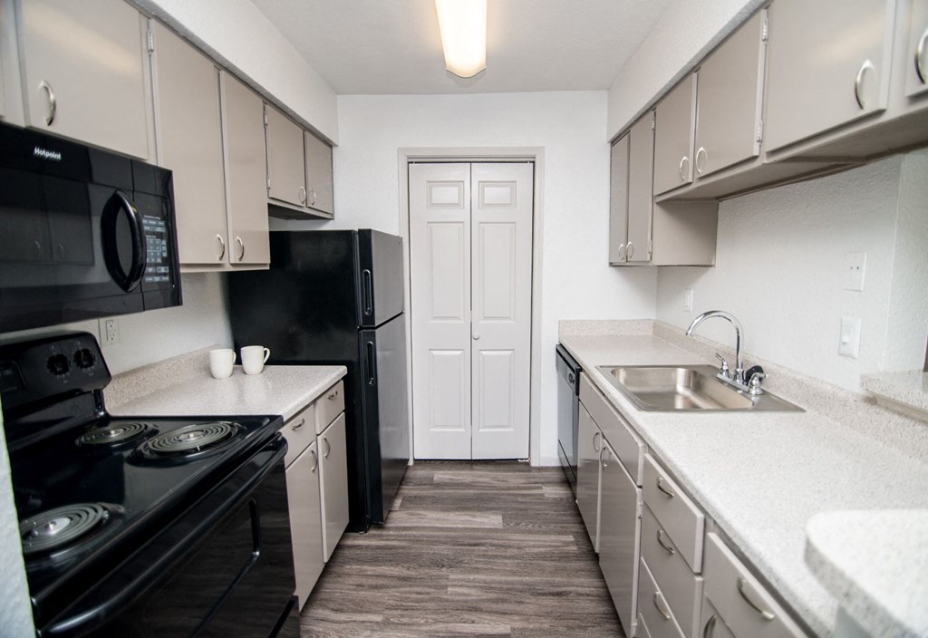 Designer kitchen with black appliances and gray cabinetry.