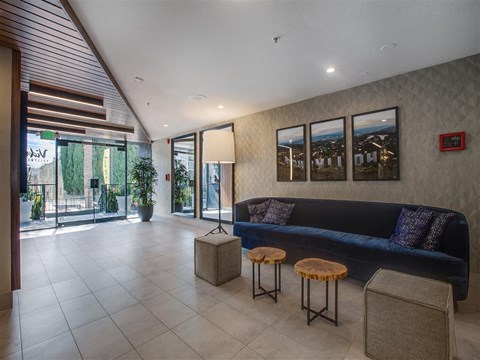 the lobby of the building has a blue couch and tables