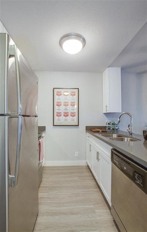 a kitchen with a stainless steel refrigerator and a sink