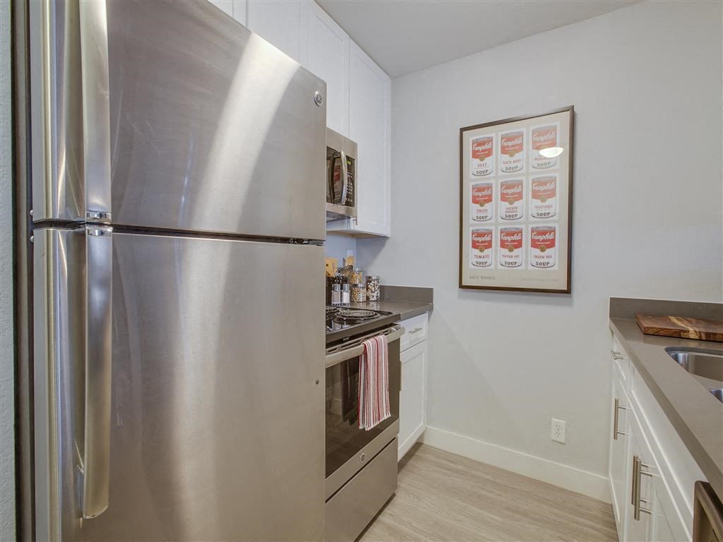 a kitchen with a stainless steel refrigerator and stove