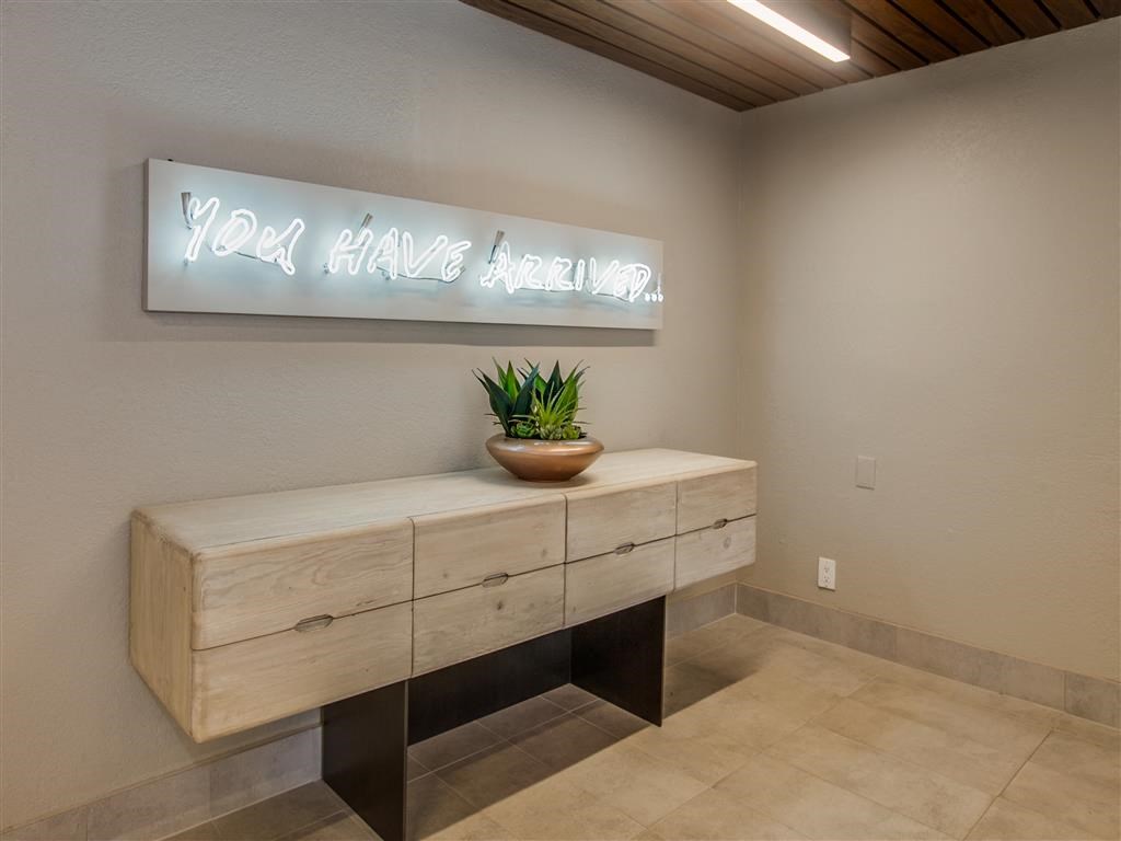 a room with a desk and a potted plant