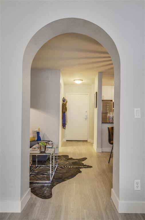 a hallway with an arched doorway leading to a living room