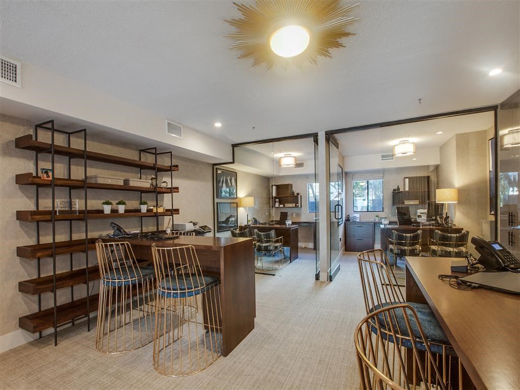 the lobby or reception area of a hotel with tables and chairs