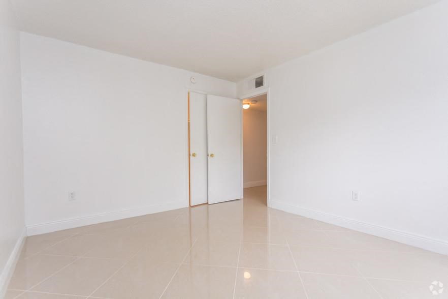 an empty living room with white walls and a door