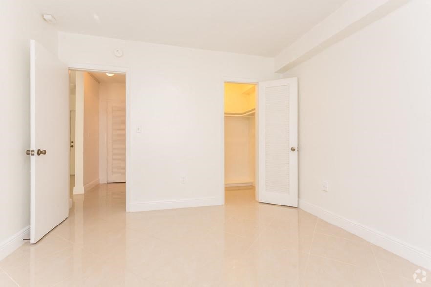 an empty living room with an open door to a closet