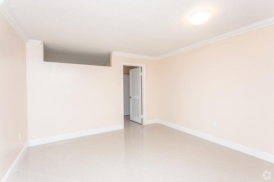 an empty living room with a door to a closet