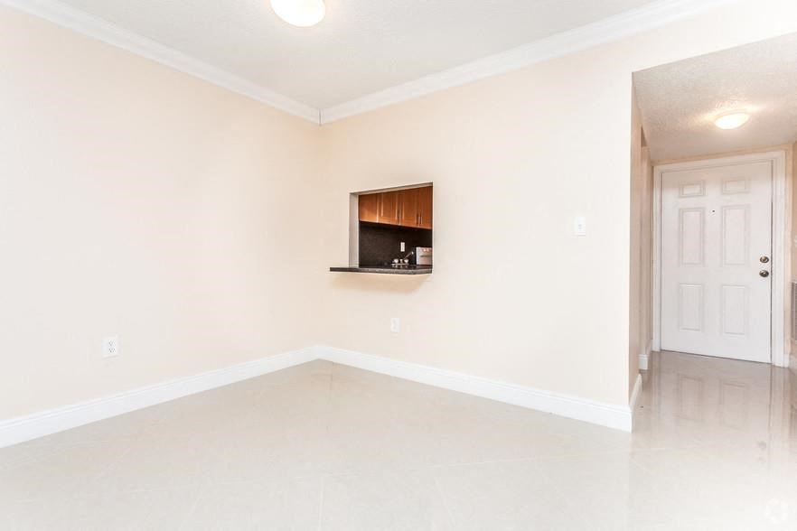 a empty living room with a tv in the wall