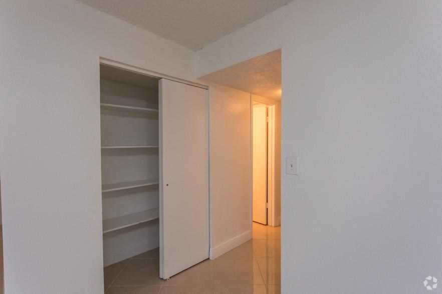 a white room with a closet and a door to a hallway