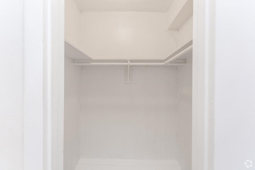 an empty white closet with a white door