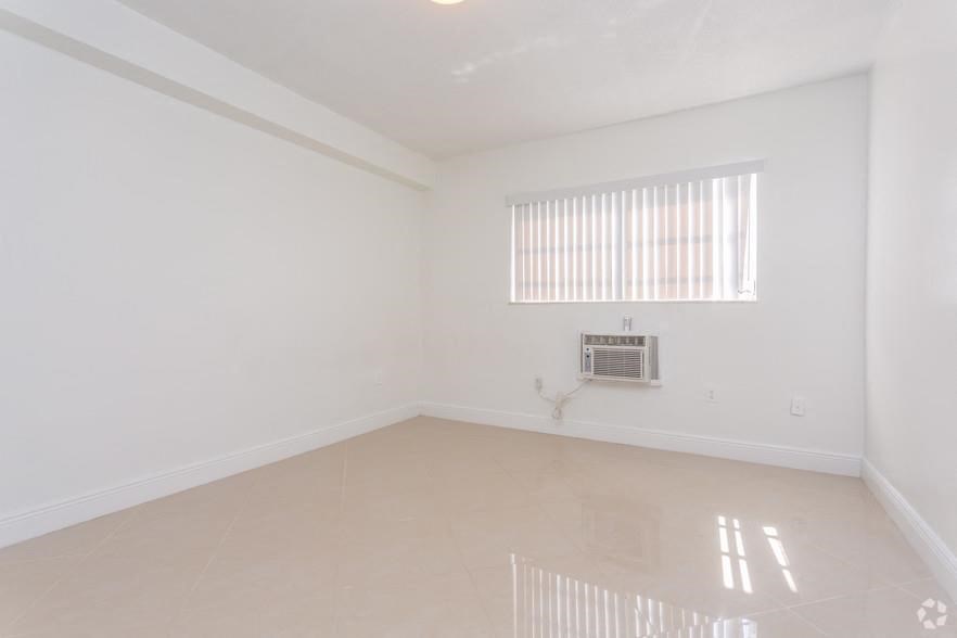 an empty living room with a window and a radiator