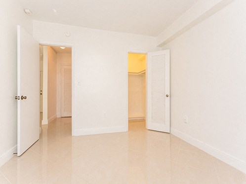 an empty living room with an open door to a closet